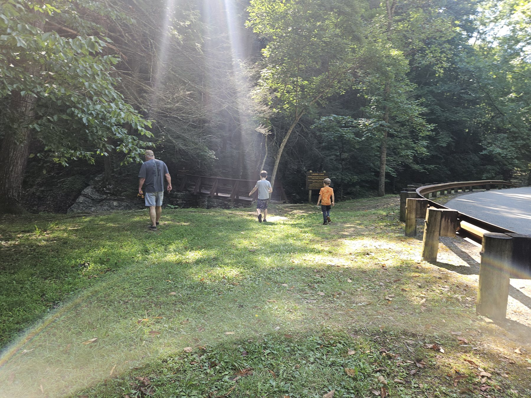 Papaw, Mason, and George walking through sunbeams toward Laurel Cave