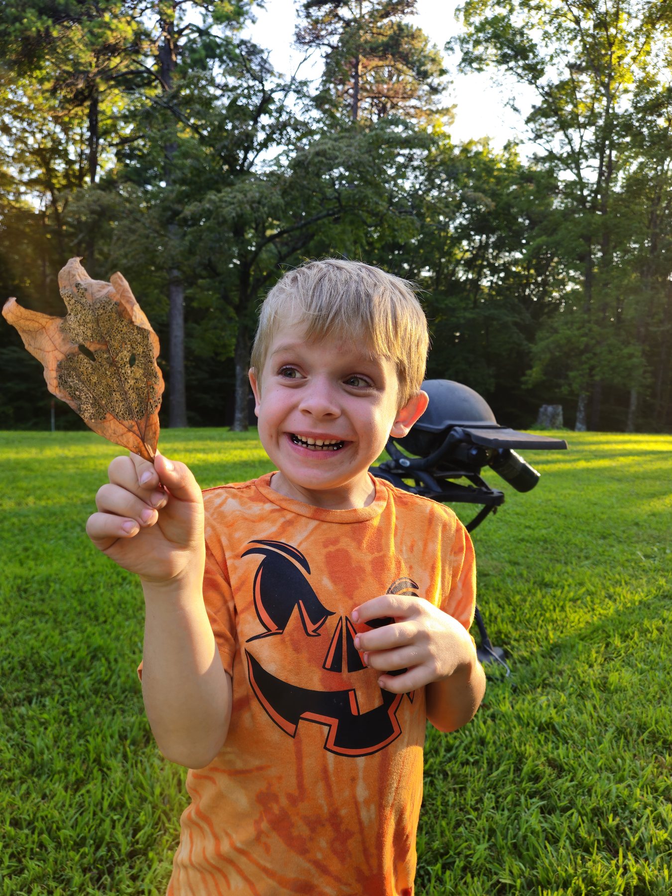 George smiling and holding a skeletonized leaf