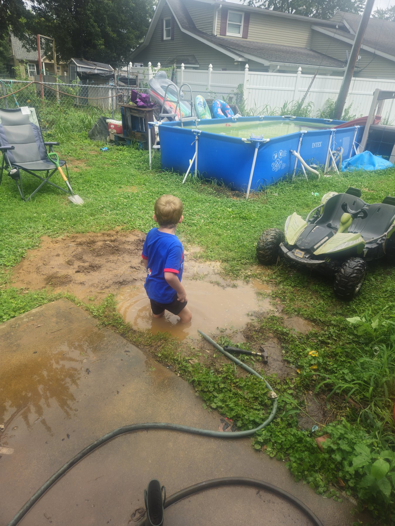 George standing knee-deep in the rain-filled hole he dug